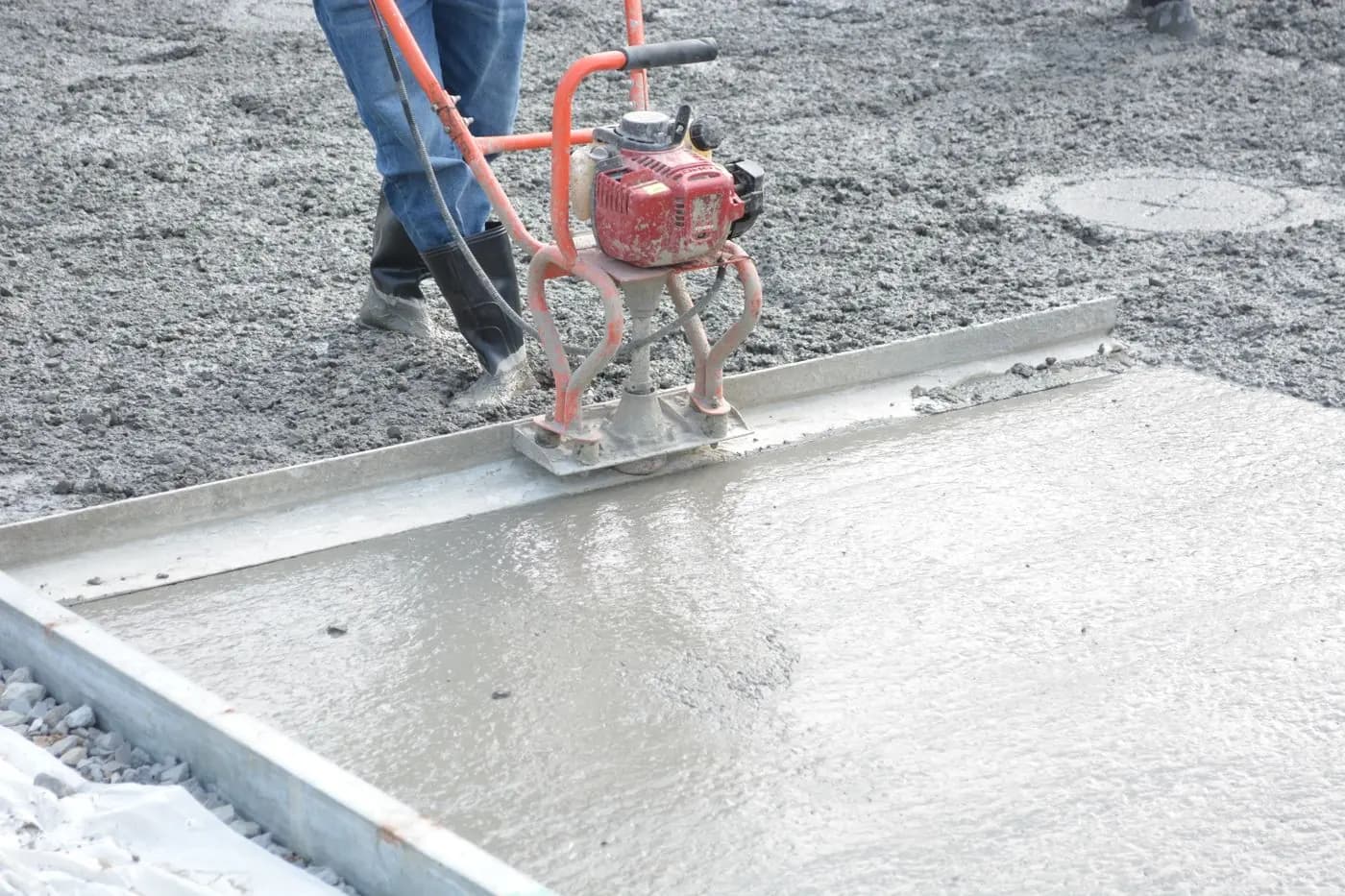 A power float levelling a freshly poured cement screed inside its formwork