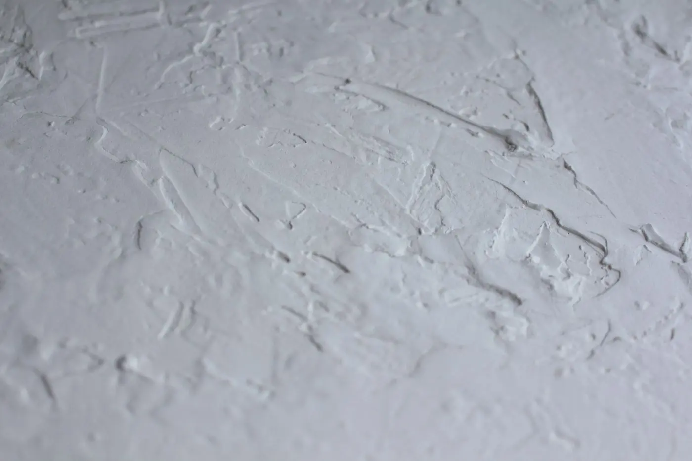 A white rendered wall surface showing the sweep of the trowel across the finish